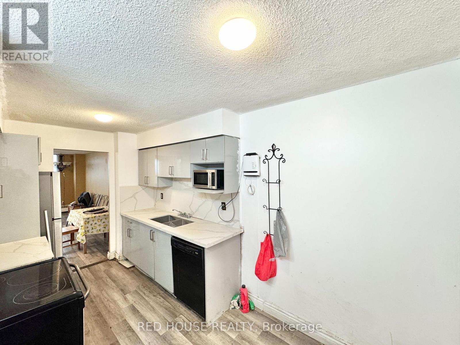 A kitchen with white cabinets and a black stove top oven.
