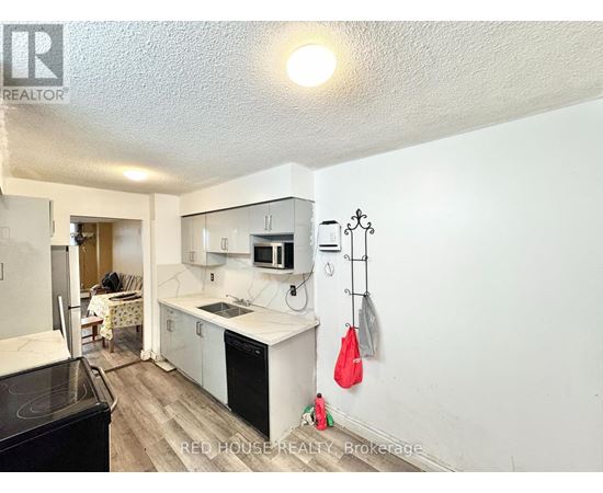 A kitchen with white cabinets and a black stove top oven.