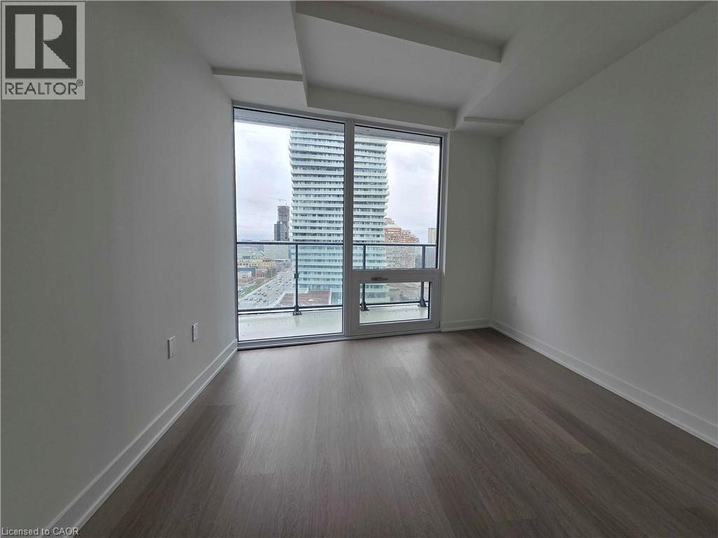 A room with a view of the city through a large window.