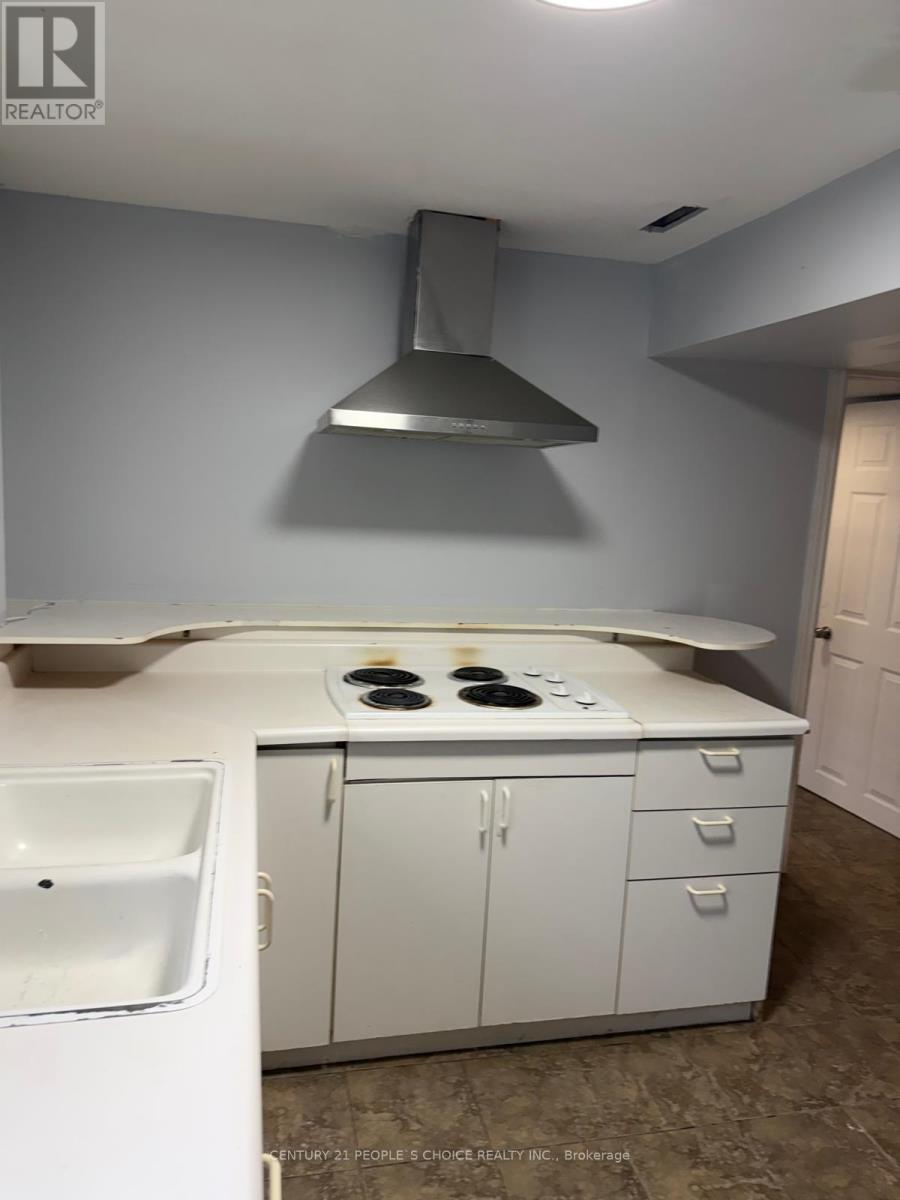 A kitchen with white cabinets and a stove top oven.