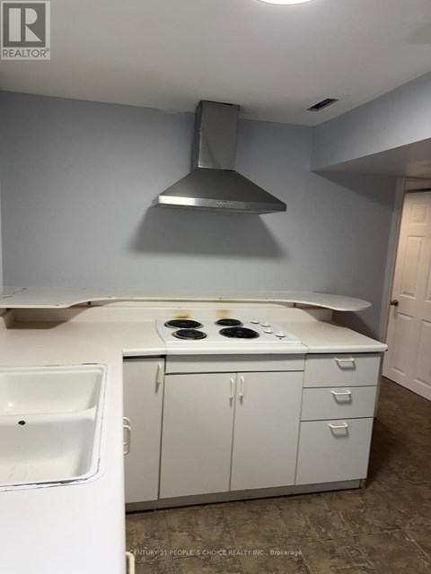 A kitchen with white cabinets and a stove top oven.