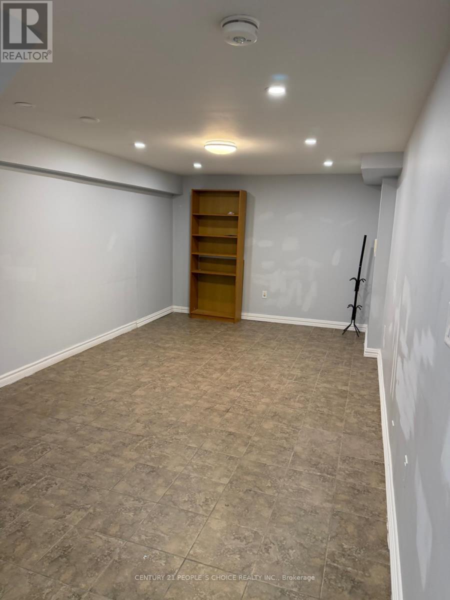 A room with a wooden bookshelf and tiled flooring.