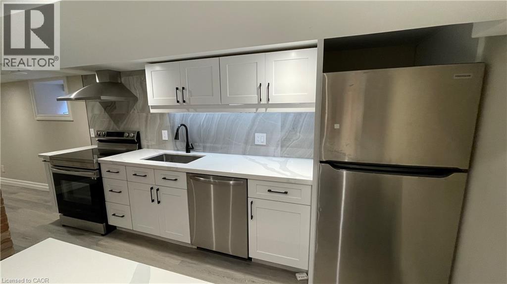 A modern kitchen with white cabinets and stainless steel appliances.
