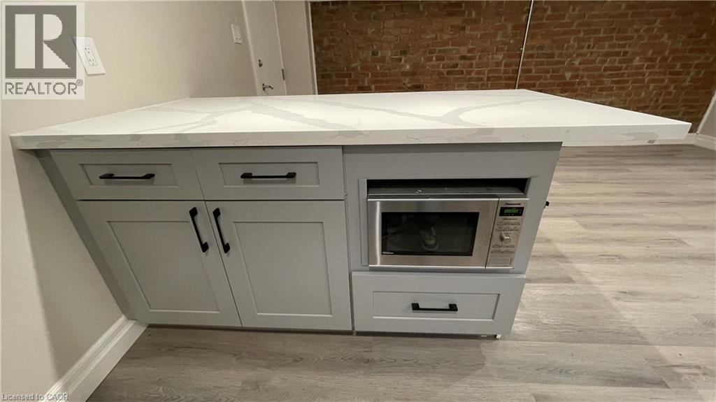 A white kitchen island with a microwave and oven built into it.