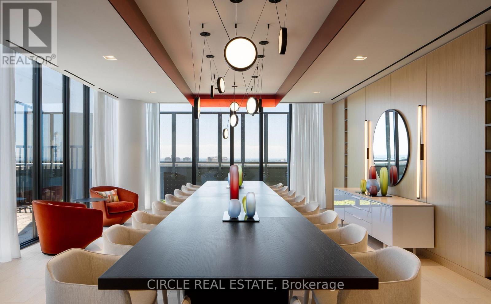 A modern dining room with a long table and chairs.