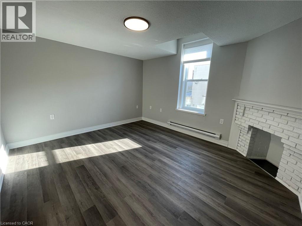 A room with a fireplace and wood flooring.