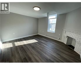 A room with a fireplace and wood flooring.