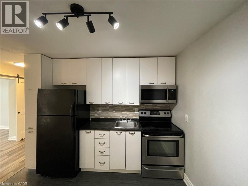 A kitchen with white cabinets and black appliances.