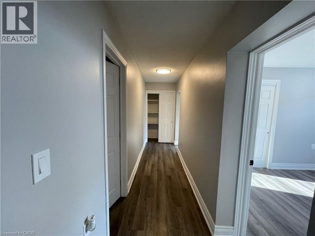A long hallway with wood floors and white walls.