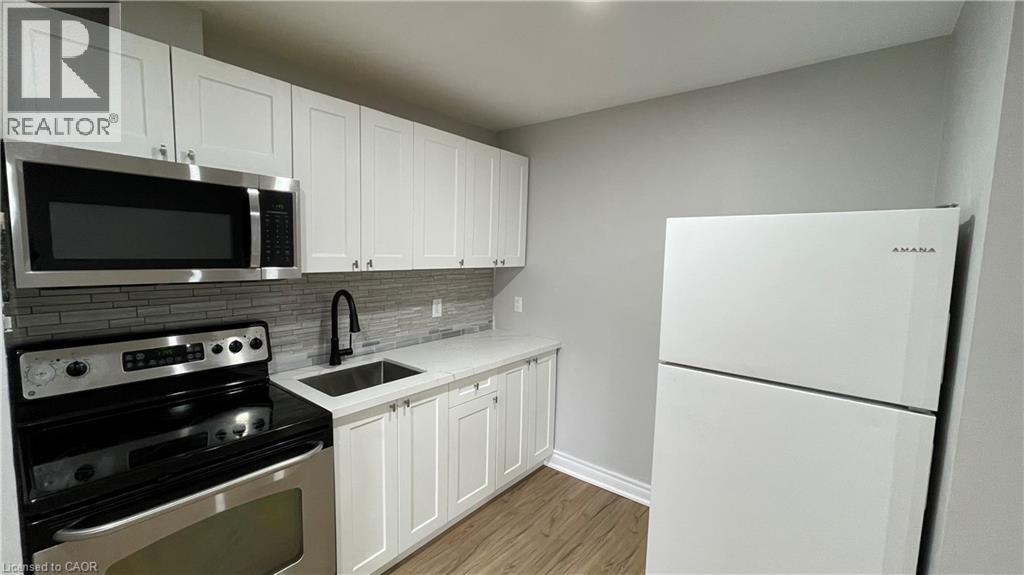 A kitchen with white cabinets and a white fridge.