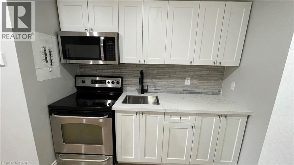 A kitchen with white cabinets and a black countertop.