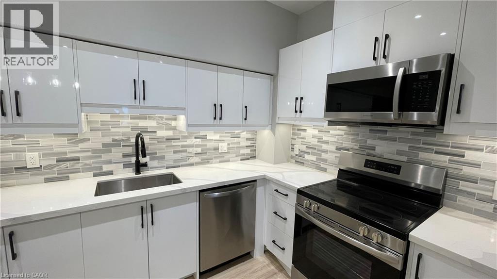A modern kitchen with white cabinets and stainless steel appliances.