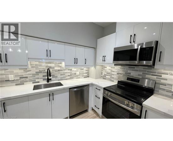A modern kitchen with white cabinets and stainless steel appliances.
