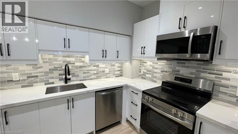 A modern kitchen with white cabinets and stainless steel appliances.