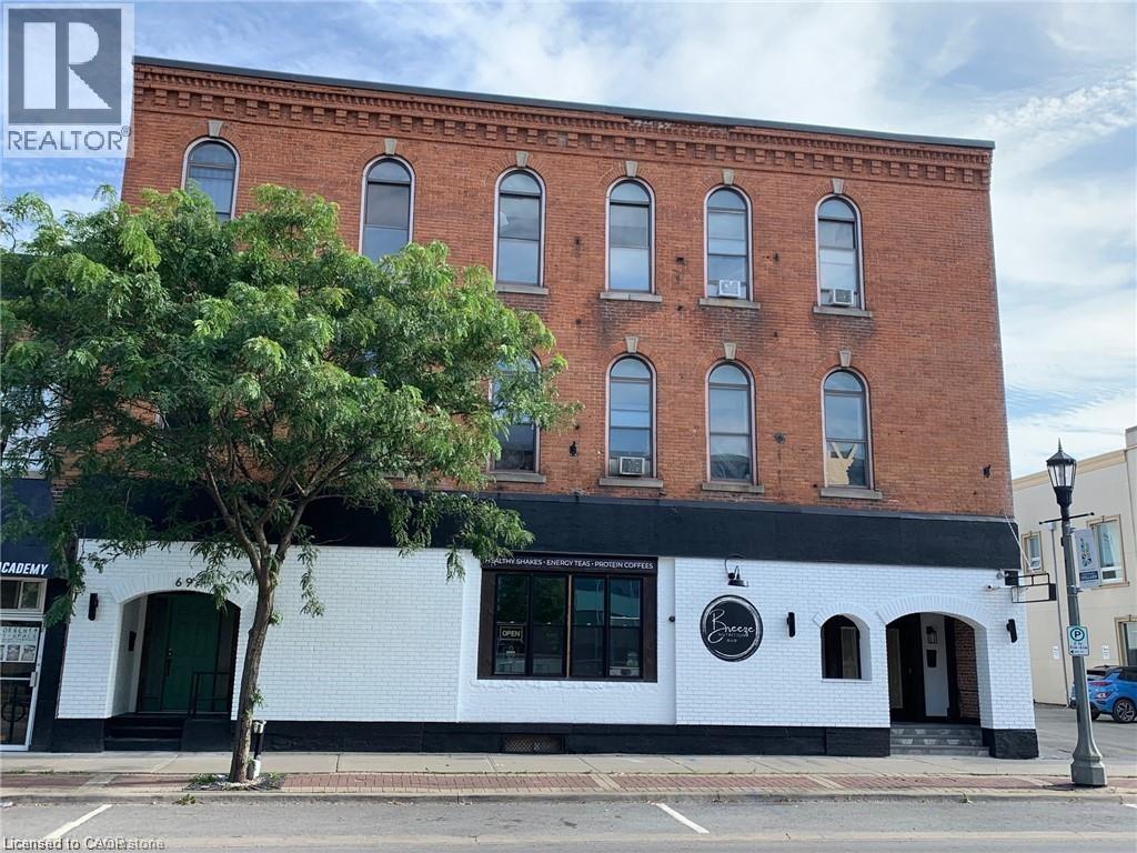 A building with a black and white facade has a Realty sign on it.