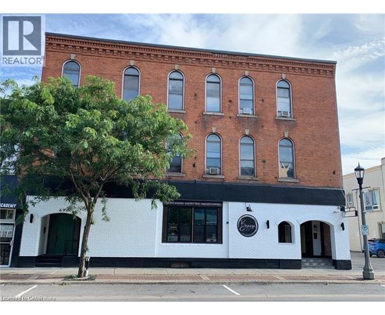 A building with a black and white facade has a Realty sign on it.