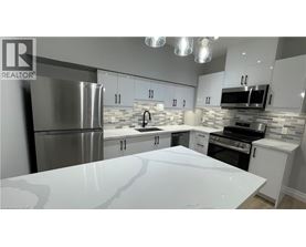 A modern kitchen with a white countertop and stainless steel appliances.