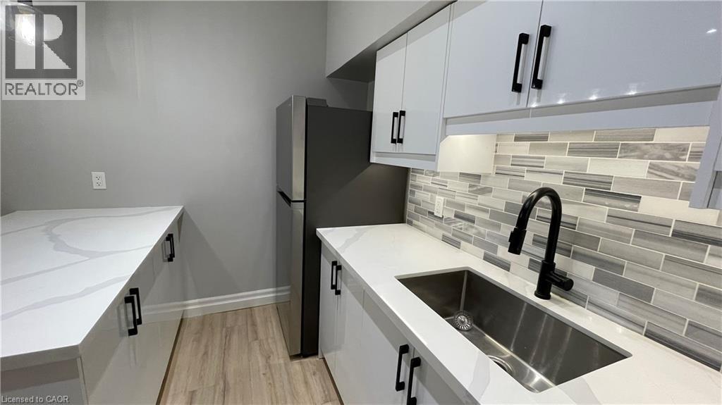 A kitchen with white cabinets and a sink.