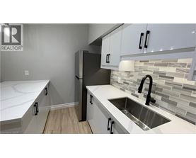 A kitchen with white cabinets and a sink.