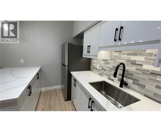 A kitchen with white cabinets and a sink.