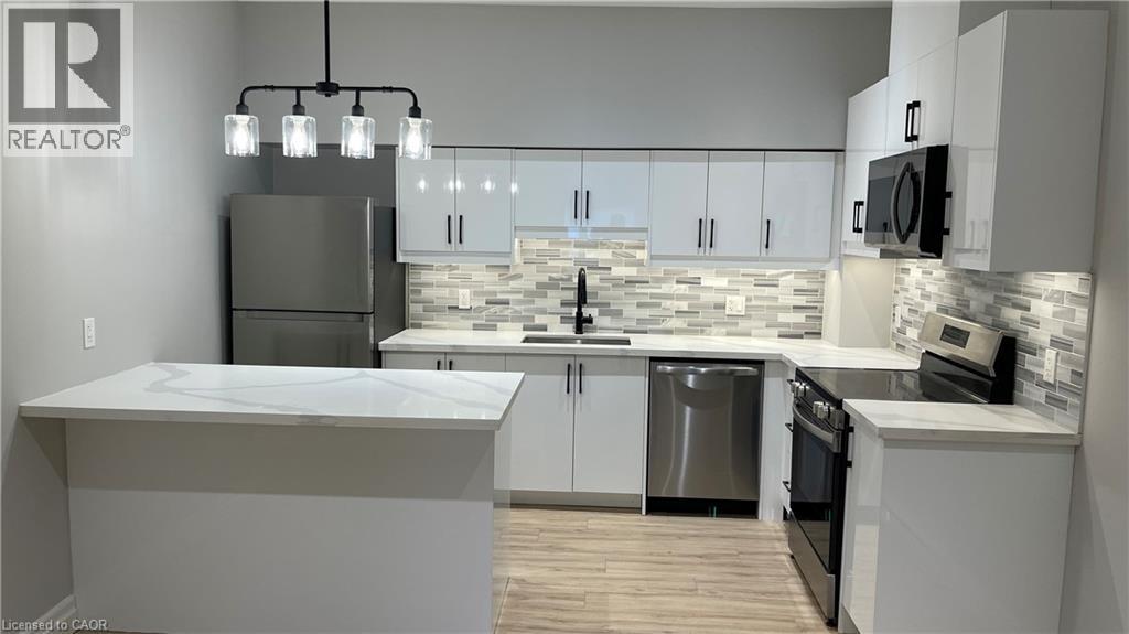 A modern kitchen with a large island and stainless steel appliances.