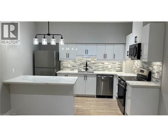 A modern kitchen with a large island and stainless steel appliances.