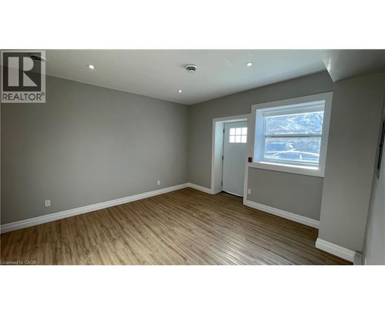 A room with a window and a door is available for rent.
