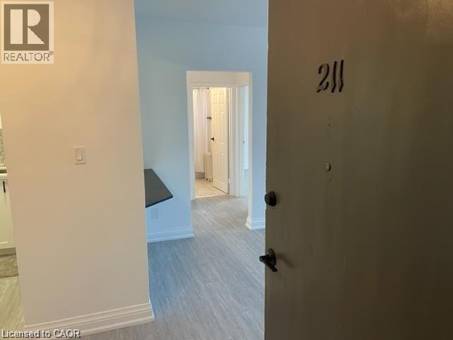 A room with a door numbered 211 and a light switch.