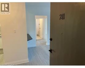 A room with a door numbered 211 and a light switch.