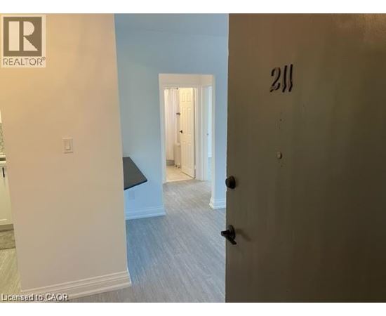 A room with a door numbered 211 and a light switch.