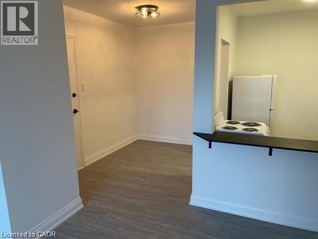 A room with a white door and a small window with a white curtain.