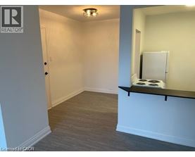 A room with a white door and a small window with a white curtain.