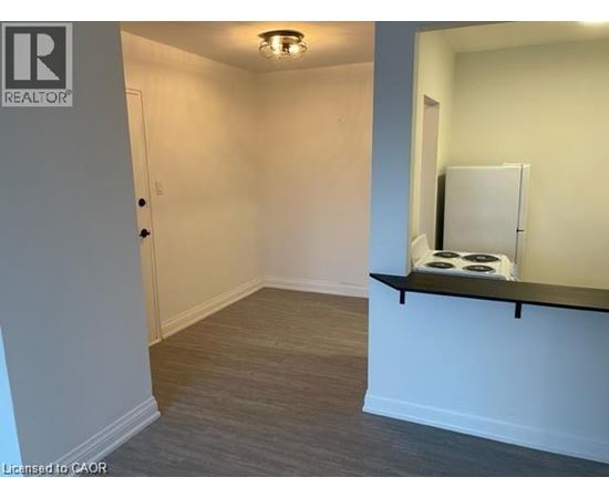 A room with a white door and a small window with a white curtain.