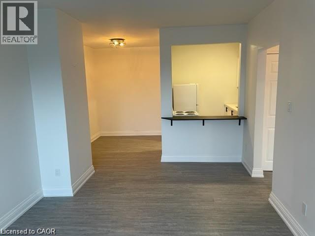 A room with a white wall and a wooden floor.