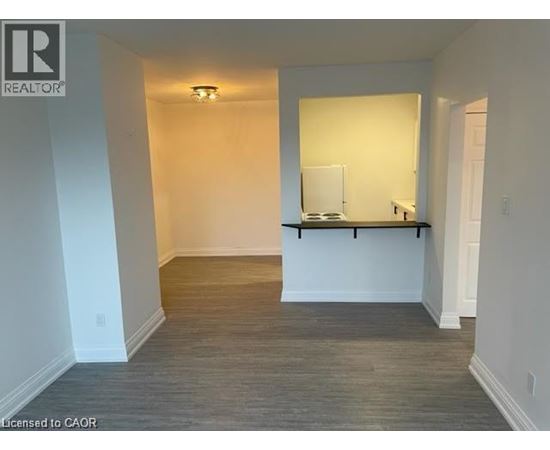A room with a white wall and a wooden floor.