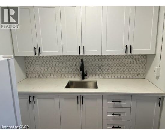 A kitchen with white cabinets and a tiled backsplash.