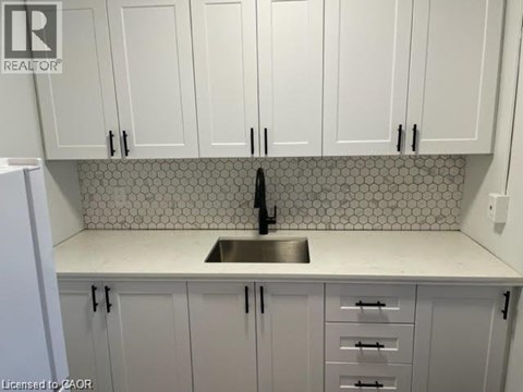 A kitchen with white cabinets and a tiled backsplash.