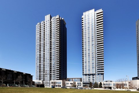Two tall buildings with many windows are in the foreground.