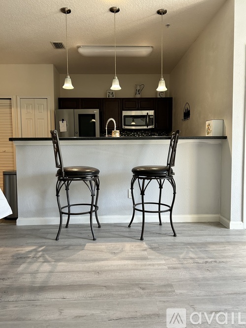 Two black bar stools are in front of a kitchen island.