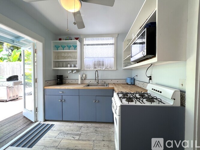 A kitchen with a blue cabinet and a white stove top oven.