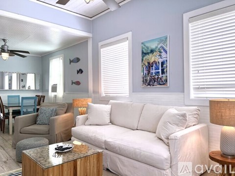 A living room with a white couch and a wooden coffee table.