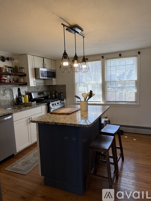 A kitchen with a granite countertop and wooden floors.