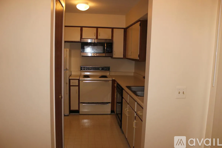 A kitchen with white appliances and wooden cabinets.