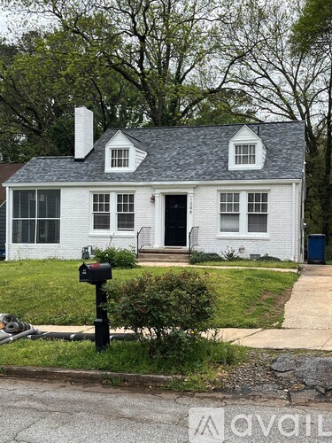 A white house with a black door and mailbox.