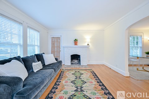 A living room with a grey couch and a fireplace.