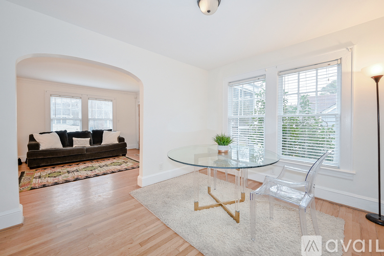 A living room with a glass table and a sofa.