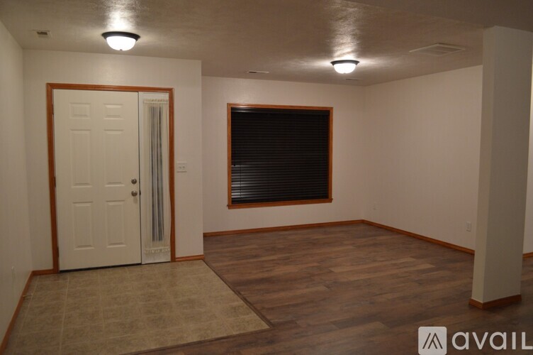 A room with a white door and a window with blinds.