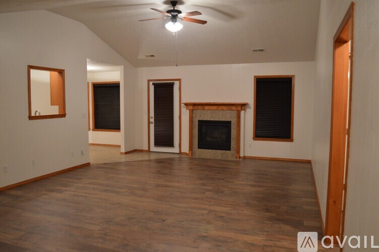A spacious room with wood flooring and a fireplace.