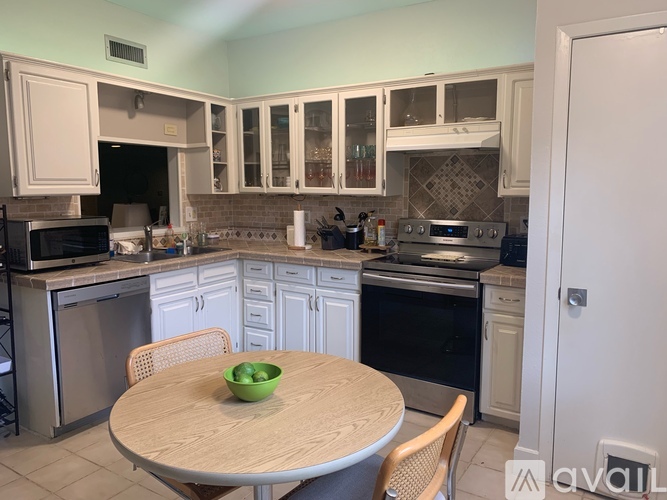 A kitchen with a table and chairs in front of it.