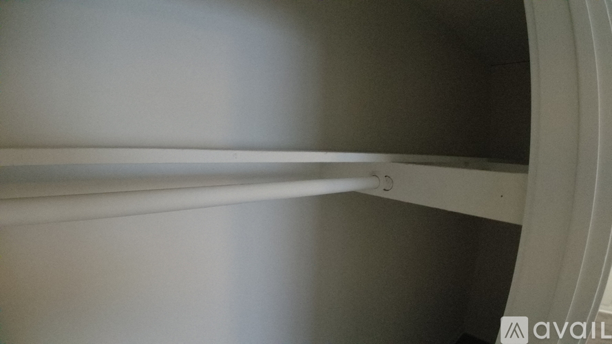 A white shelf with a metal rod on it.